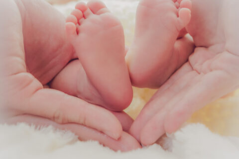 パパとママの手の中に赤ちゃんの可愛い足